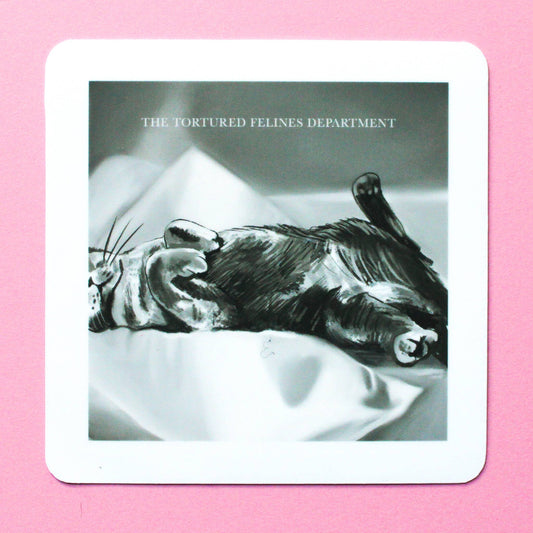 Cat lying on its back with 'The Tortured Felines Department' text on a pink background